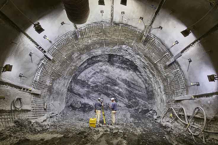Zwei Personen stehen vor einer Gesteinswand