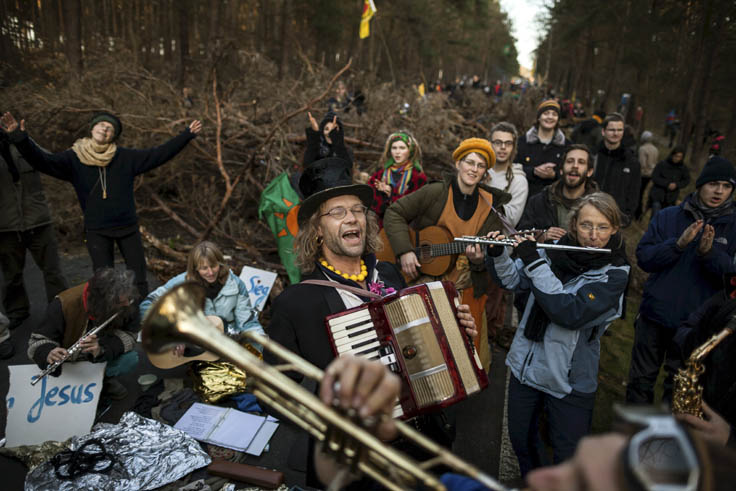 Menschen mit Schildern und Musikinstrumenten
