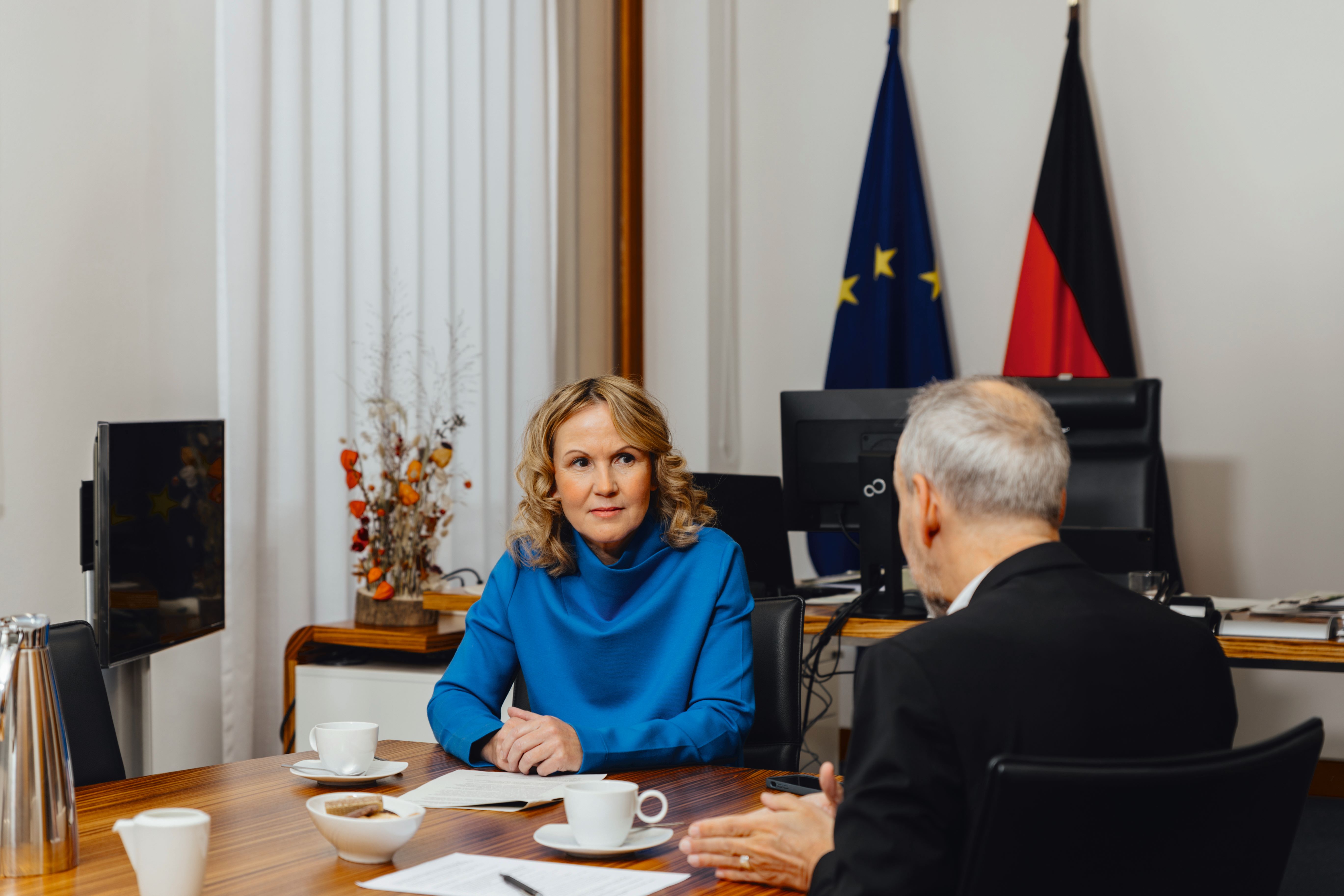 Eine Frau sitzt einem Mann gegenüber, diese sind im Gespräch